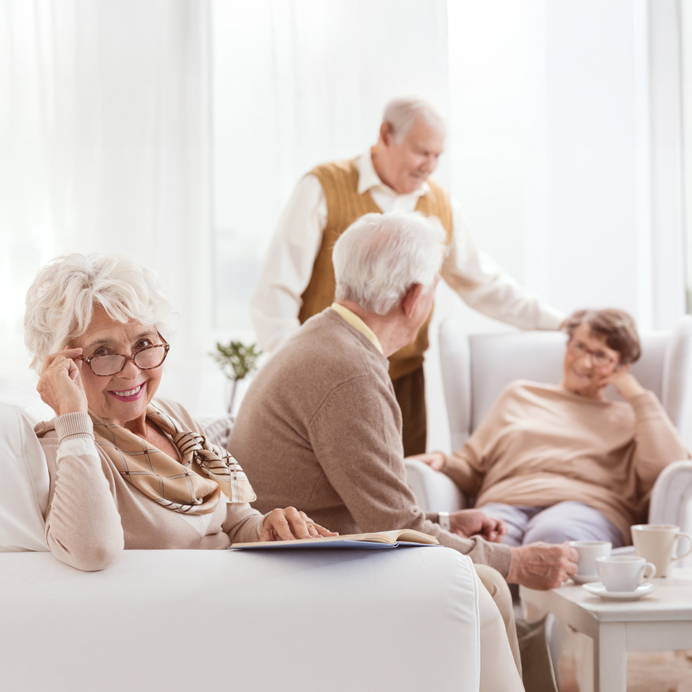 Gemeinsam wohnen im Alter – ambulant betreute Senioren‑Wohngemeinschaft in Cottbus Vier Seniorinnen und Senioren genießen bei Kaffee und Gespräch ein helles, gemütliches Wohnzimmer – Senioren‑Wohngemeinschaft Cottbus, ambulant betreut mit individueller Pflege und familiärer Atmosphäre